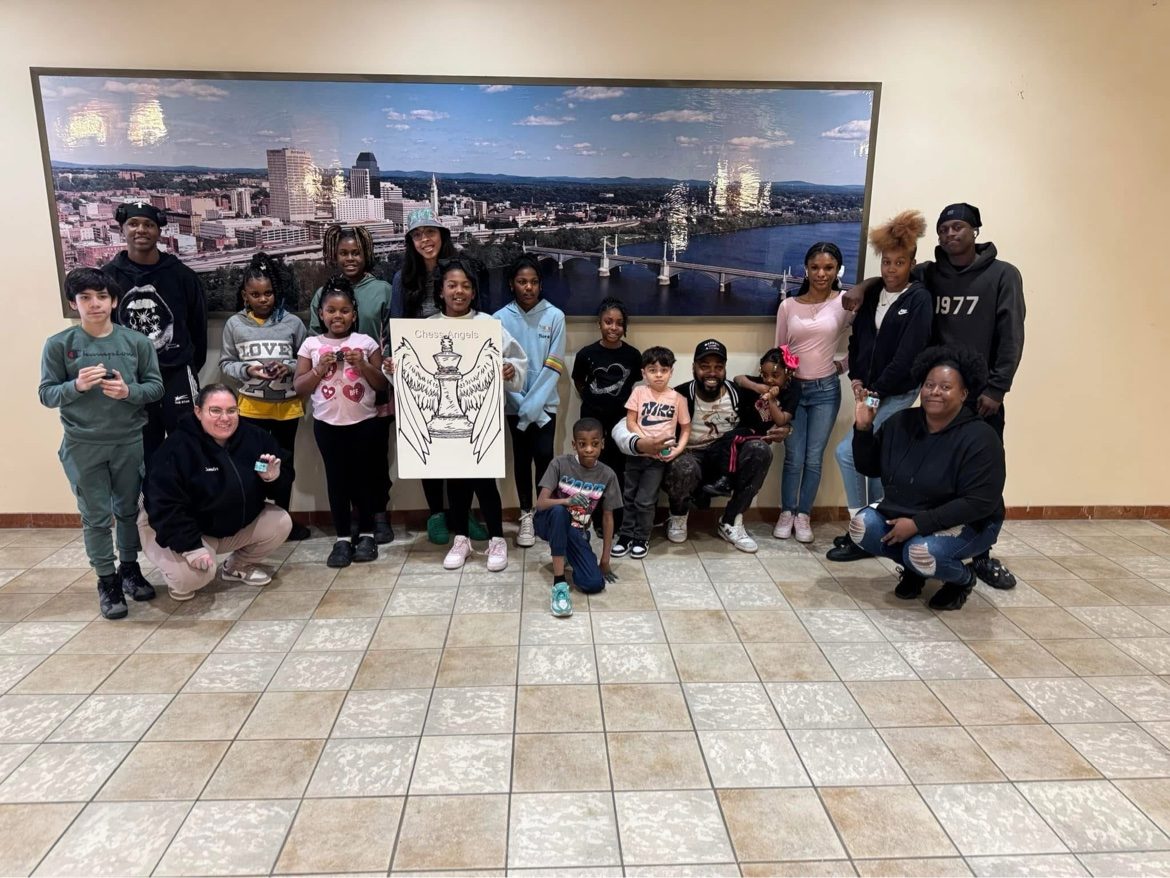 Chess Angels community group holding the organization's sign in Springfield