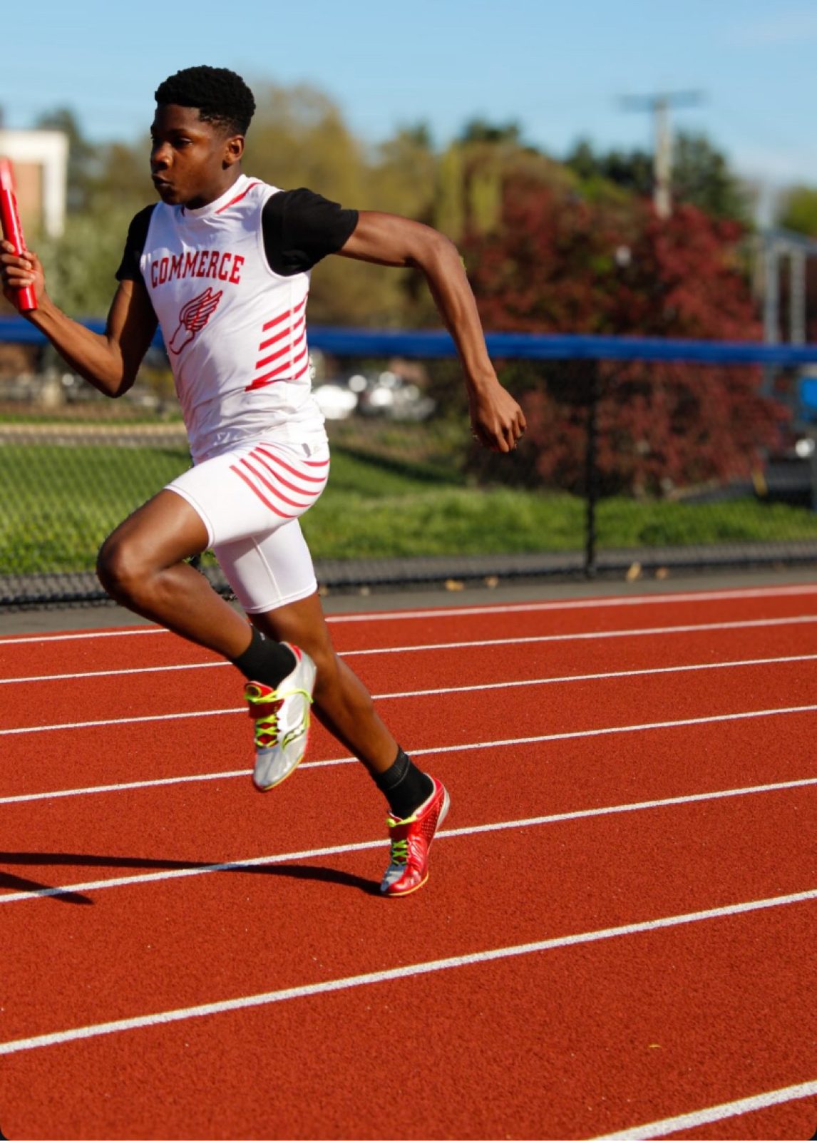 Relay runner sprinting with the baton on the track